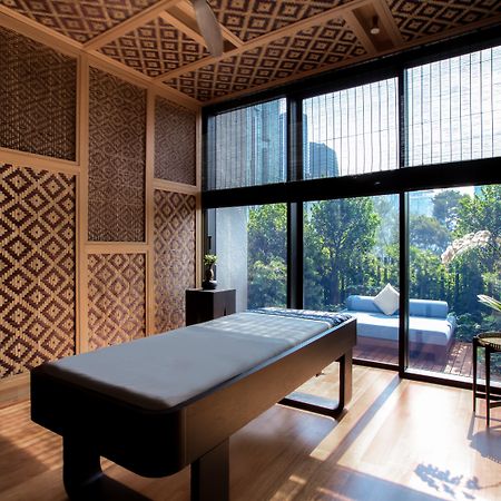 The Ruma Hotel And Residences Куала Лумпур Екстериор снимка The photo displays a tranquil room designed for relaxation or therapy. The room features a massage table centered in the space, with elegant wooden accents. The walls are adorned with intricate geometric patterns, contributing to a serene atmosphere.