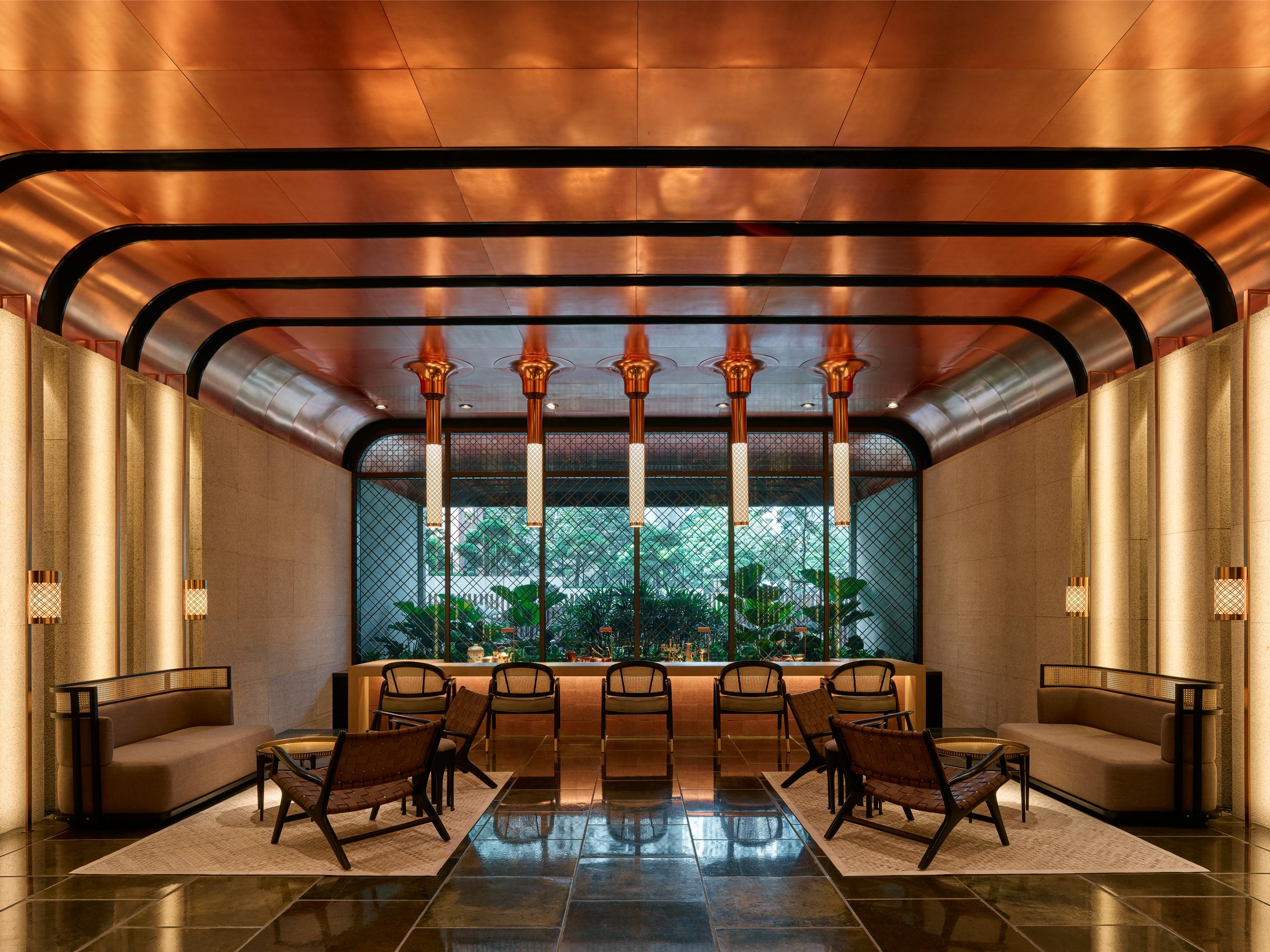 The Ruma Hotel And Residences Куала Лумпур Екстериор снимка The image shows a stylish interior space with a modern and elegant design. The walls have a sleek, warm-toned finish, and there are large windows that provide natural light. The ceiling features striking architectural lines, likely in a metallic mate