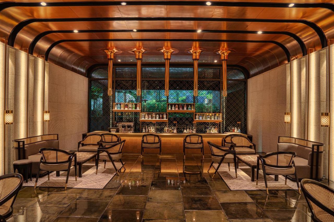 The Ruma Hotel And Residences Куала Лумпур Екстериор снимка The photo shows a stylish interior of a bar or lounge area. The space features a combination of elegant materials, including polished metal accents and warm lighting. A wooden bar counter is centrally located, with several shelves displaying various 