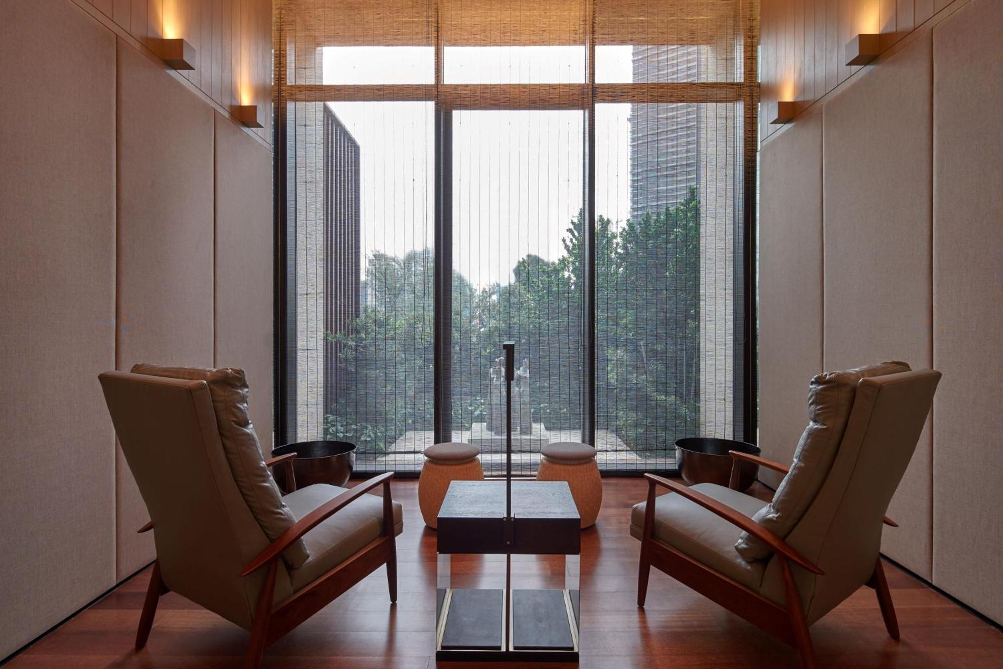 The Ruma Hotel And Residences Куала Лумпур Екстериор снимка The photo depicts a minimalist interior space, featuring two stylish chairs positioned across from each other. Between them, there's a sleek table with a simple design. The walls are finished with a light color, contributing to a serene ambiance. Lar